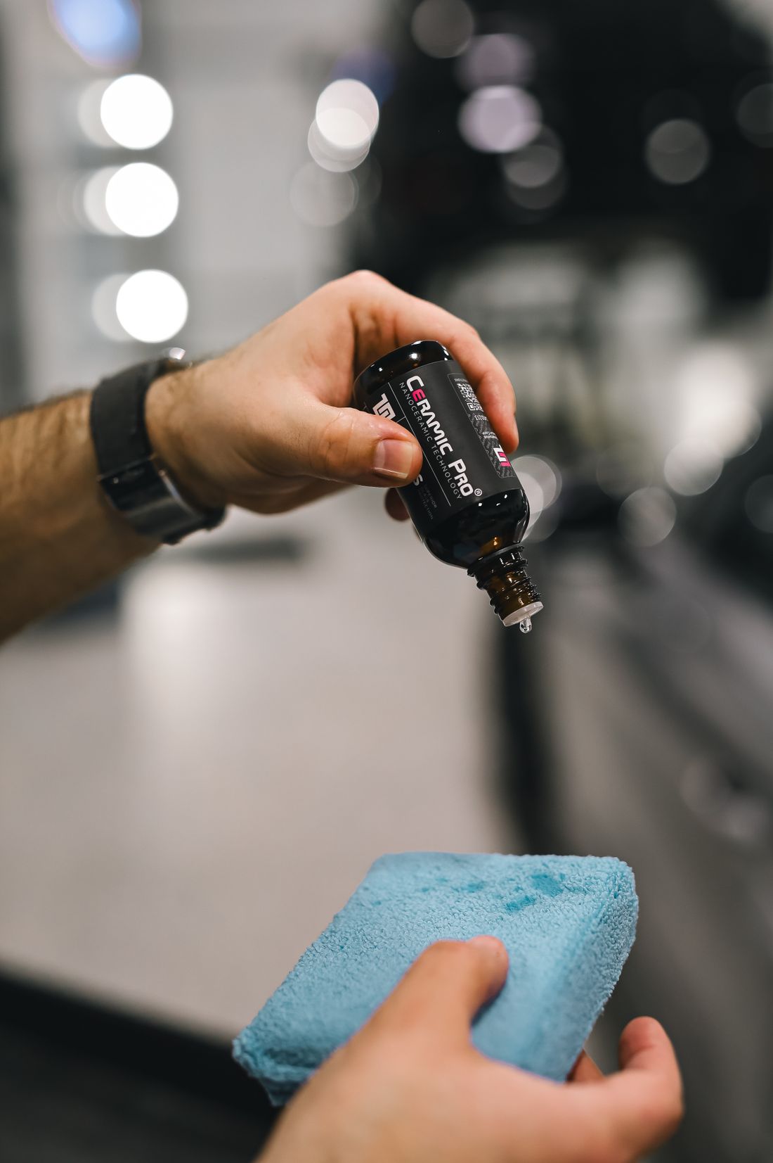 Ceramic coating dripped onto an applicator pad during professional application — Fishers studio