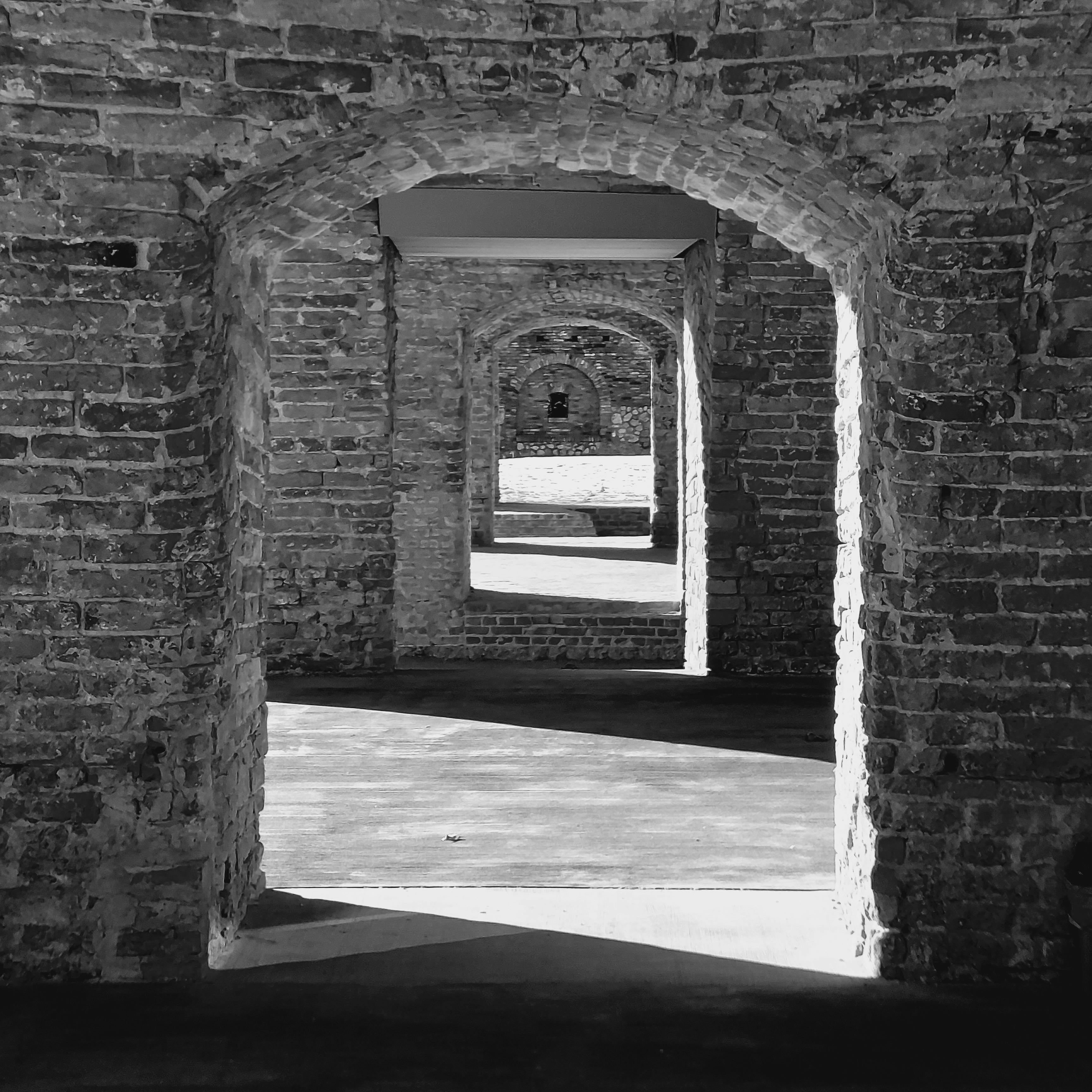 Intriguing black and white photo of medieval stone archways creating a captivating passage.