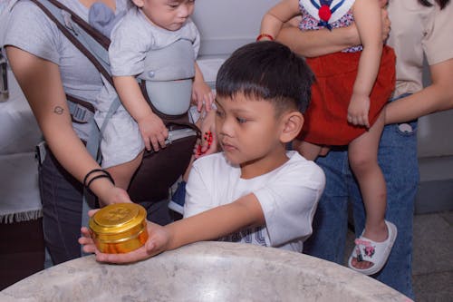 A Child Holding a Round Golden Box