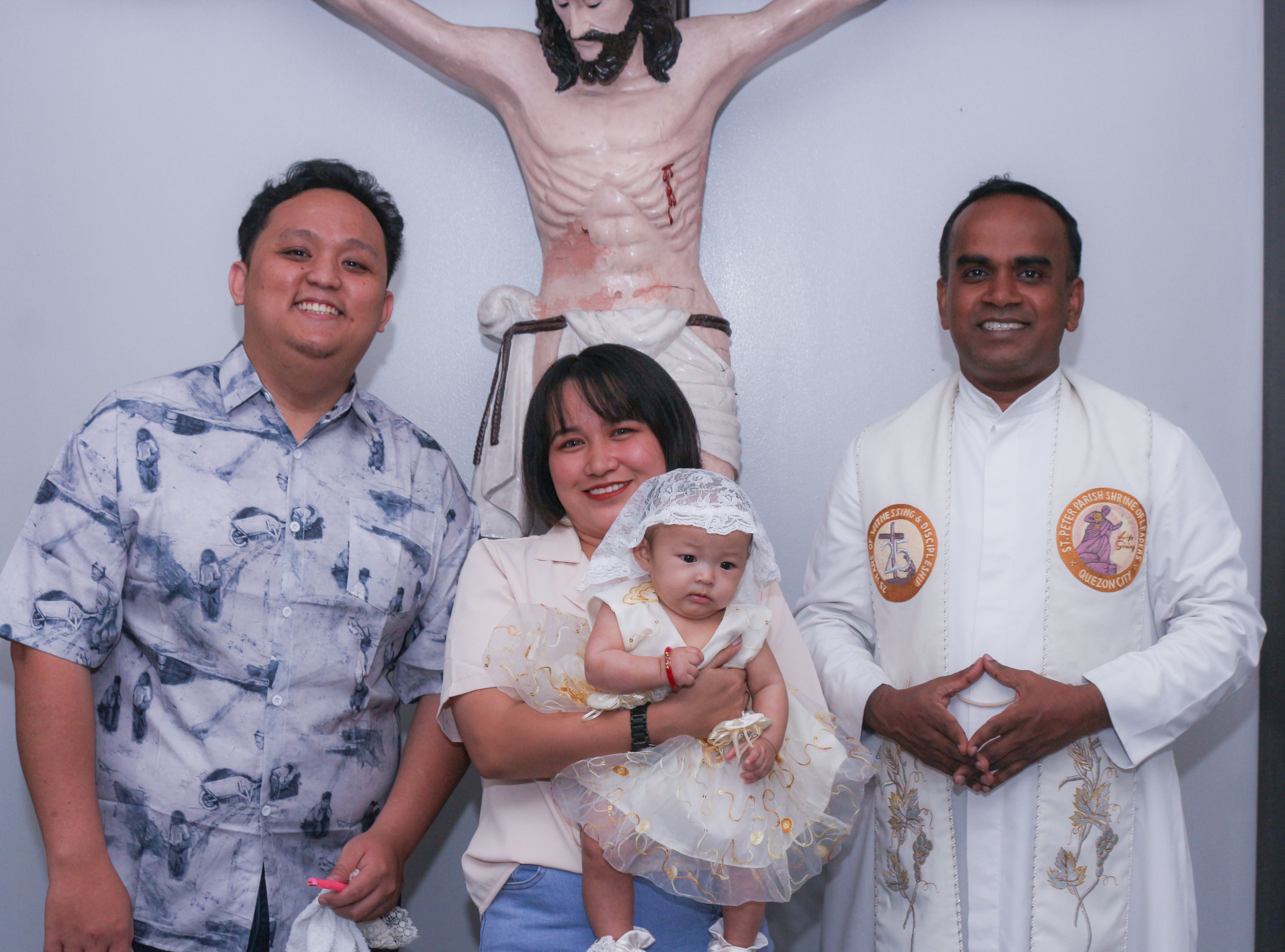 Family and priest with baby during a baptism ceremony.