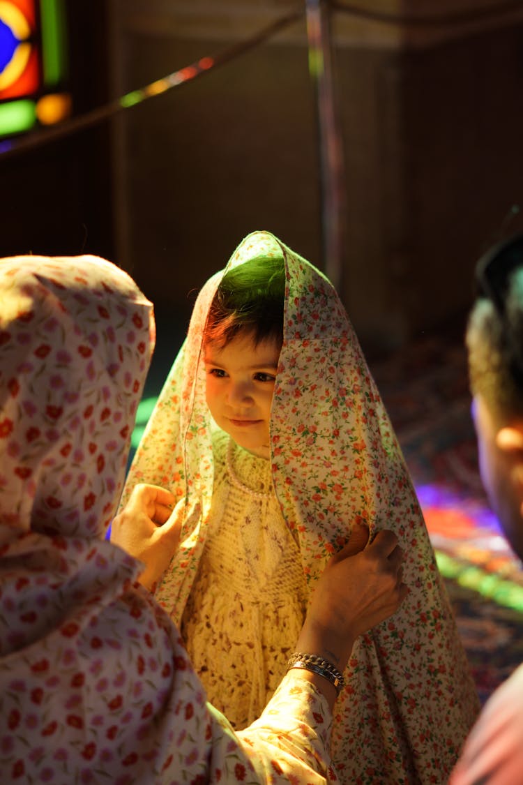 Mother Dressing Daughter In Dress And Veil