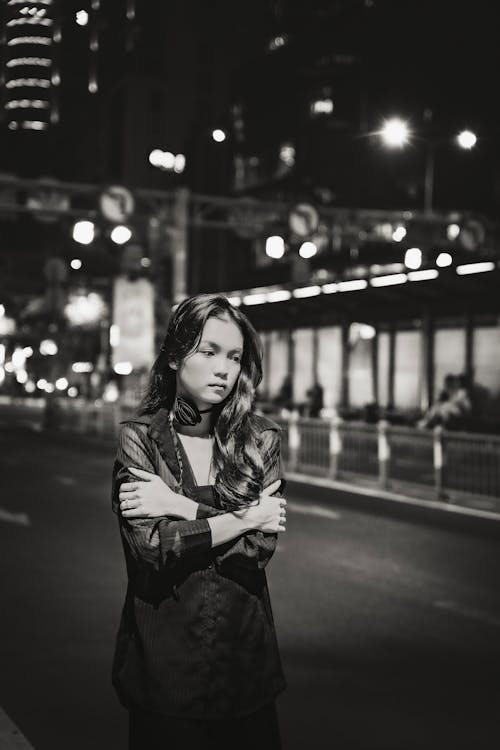 Woman with Arms Crossed on Street at Night