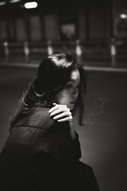 Woman Sitting with Hand on Shoulder in Black and White