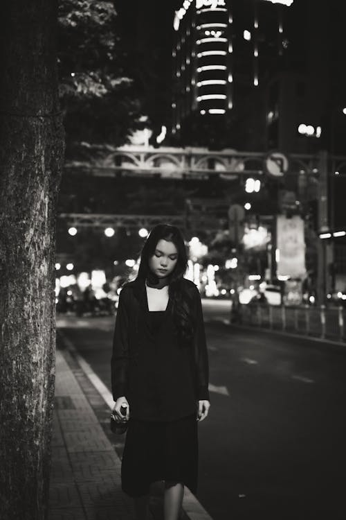 A woman in black dress standing on the street