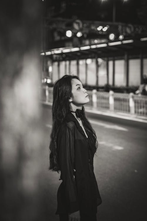 Woman Standing on Street at Night