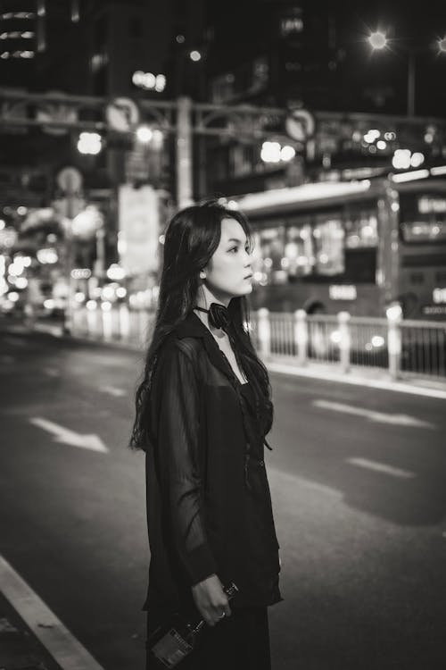 A woman standing on the street at night