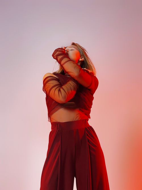 Free Elegant fashion portrait of a woman in a striking red outfit against a gradient background. Stock Photo