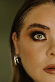 Detailed close-up portrait of a woman's eye, showcasing impeccable makeup and striking gaze.