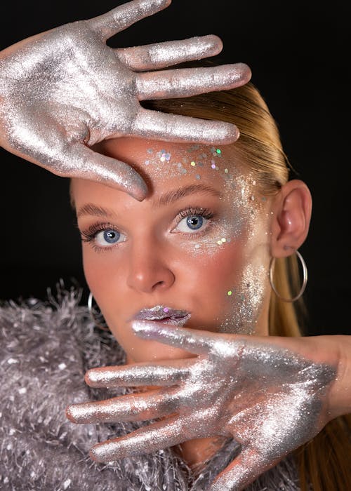 Woman with Silver Glitter Paint on Hands and Face