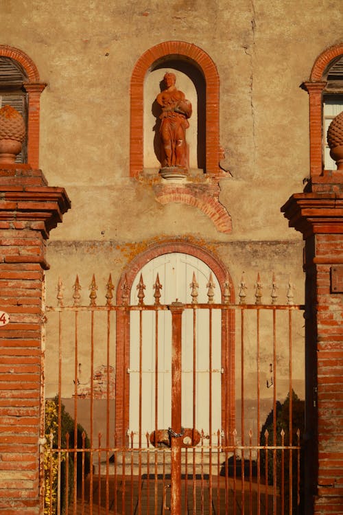 Sculpture on Wall behind Gate