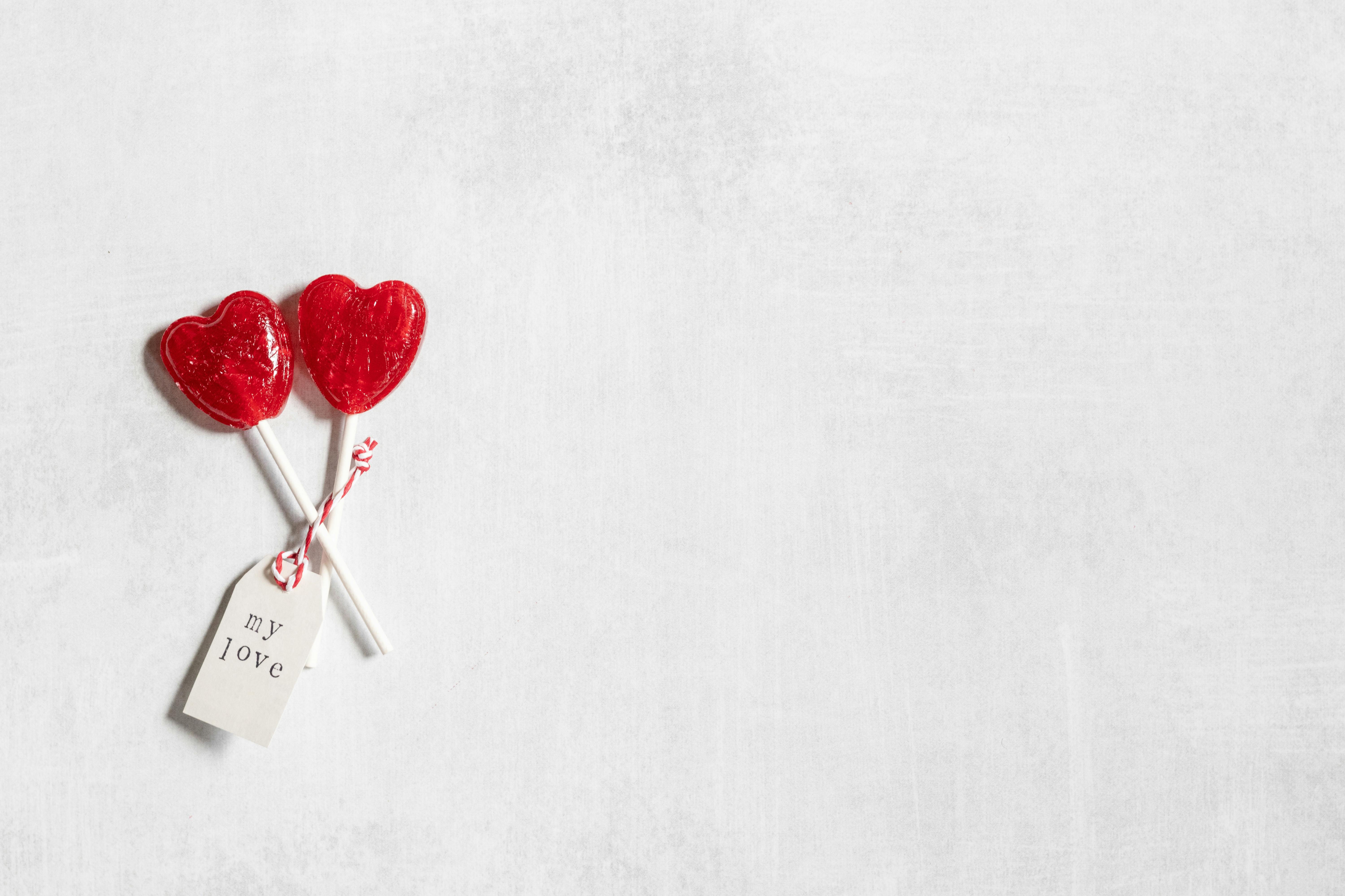 Two lollipops with hearts on a white background · Free Stock Photo