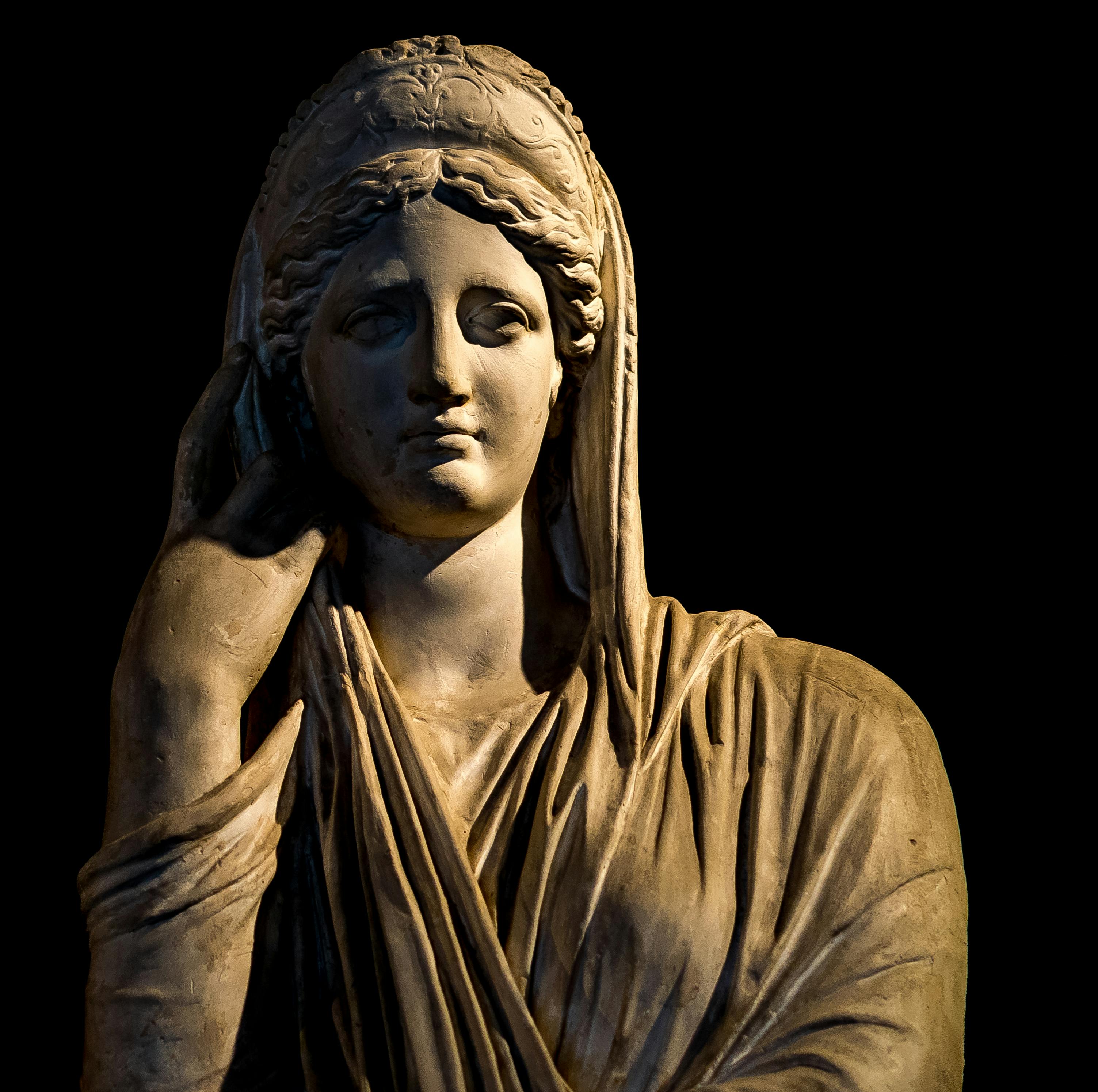 Close-up of an ancient stone statue with detailed carving and dramatic lighting.