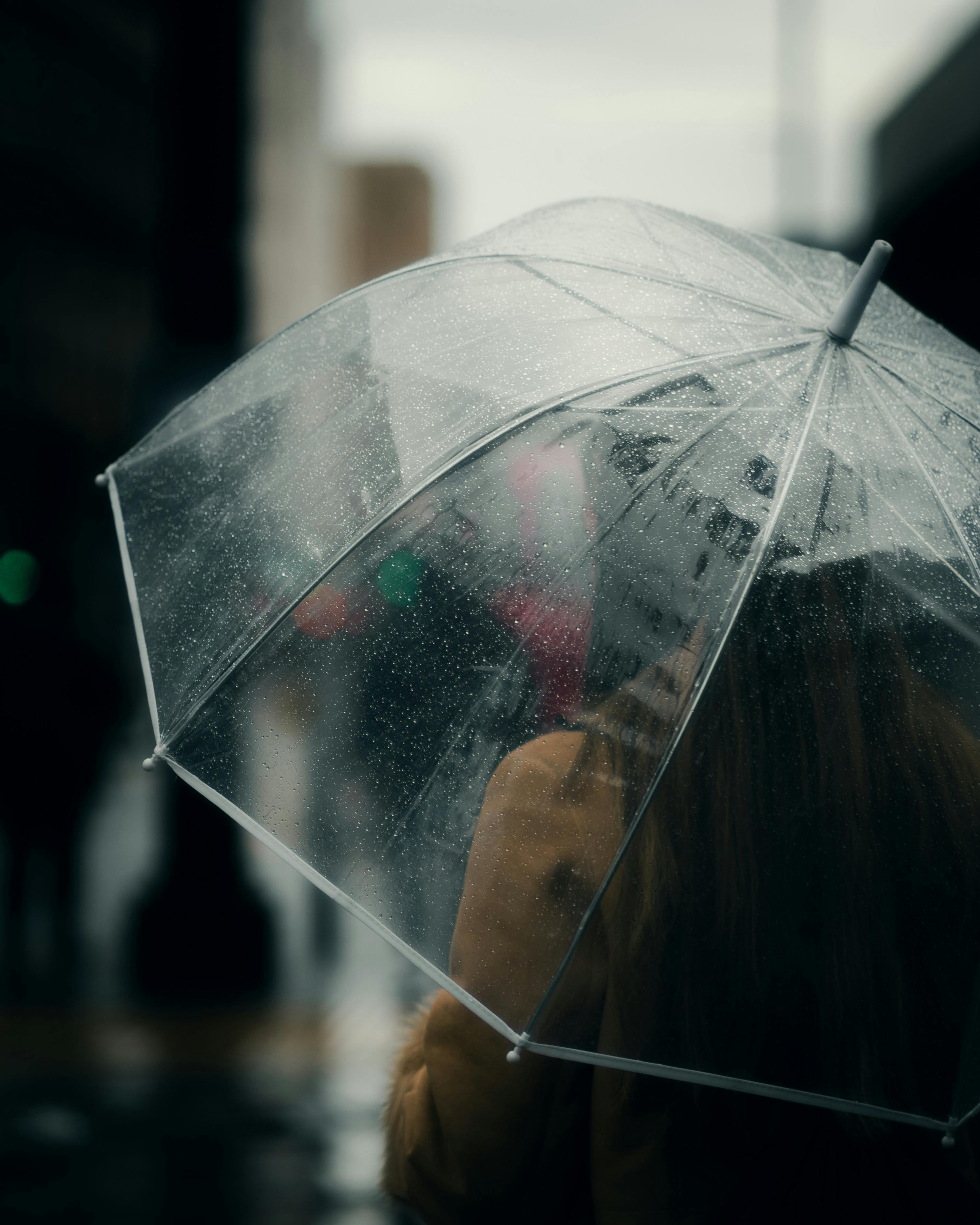 A woman walking with an umbrella on a rainy day in Manchester, England.