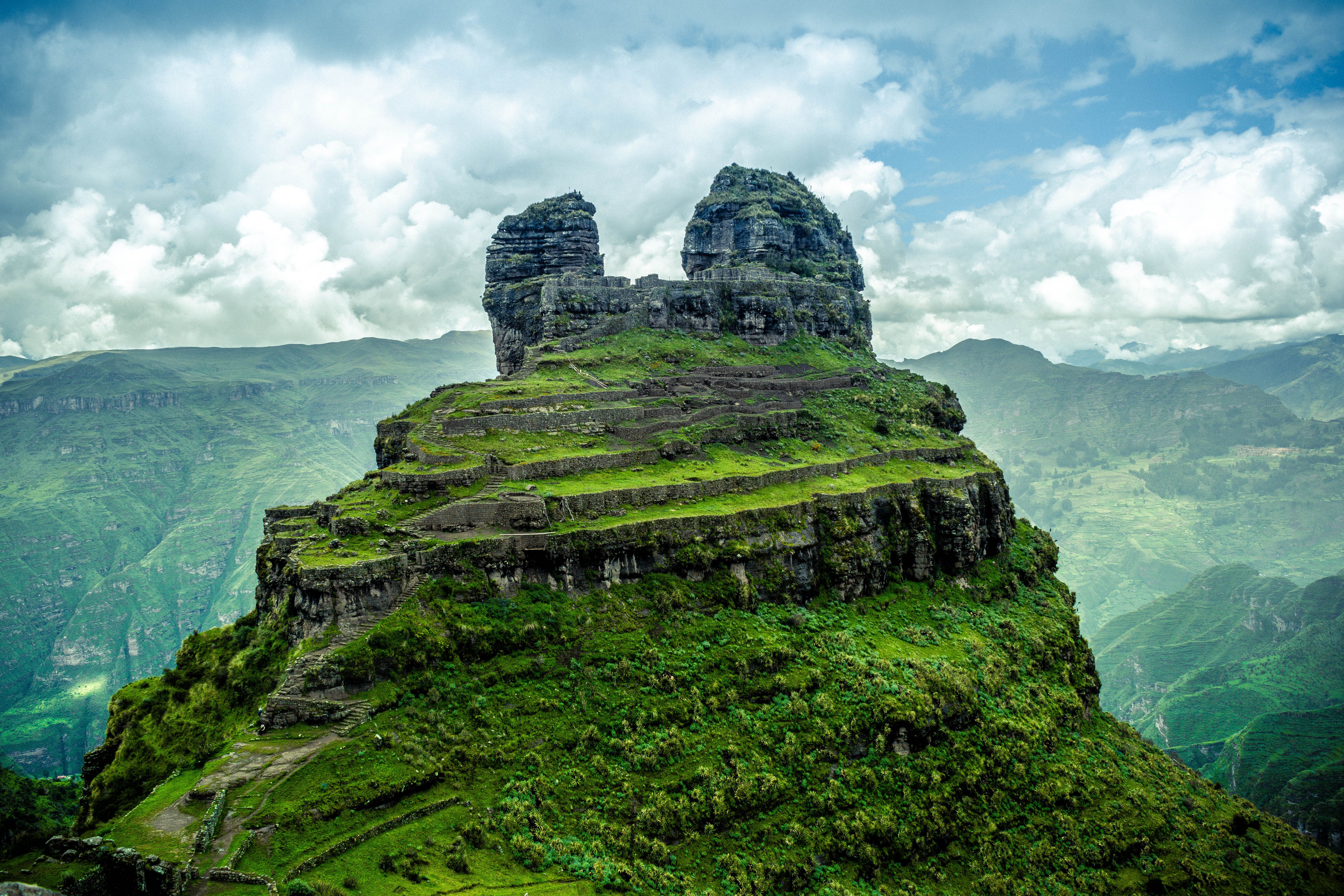 Rock Formation on Green Hill · Free Stock Photo