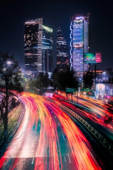 Vibrant night cityscape with traffic light trails and illuminated skyscrapers in Mexico City.