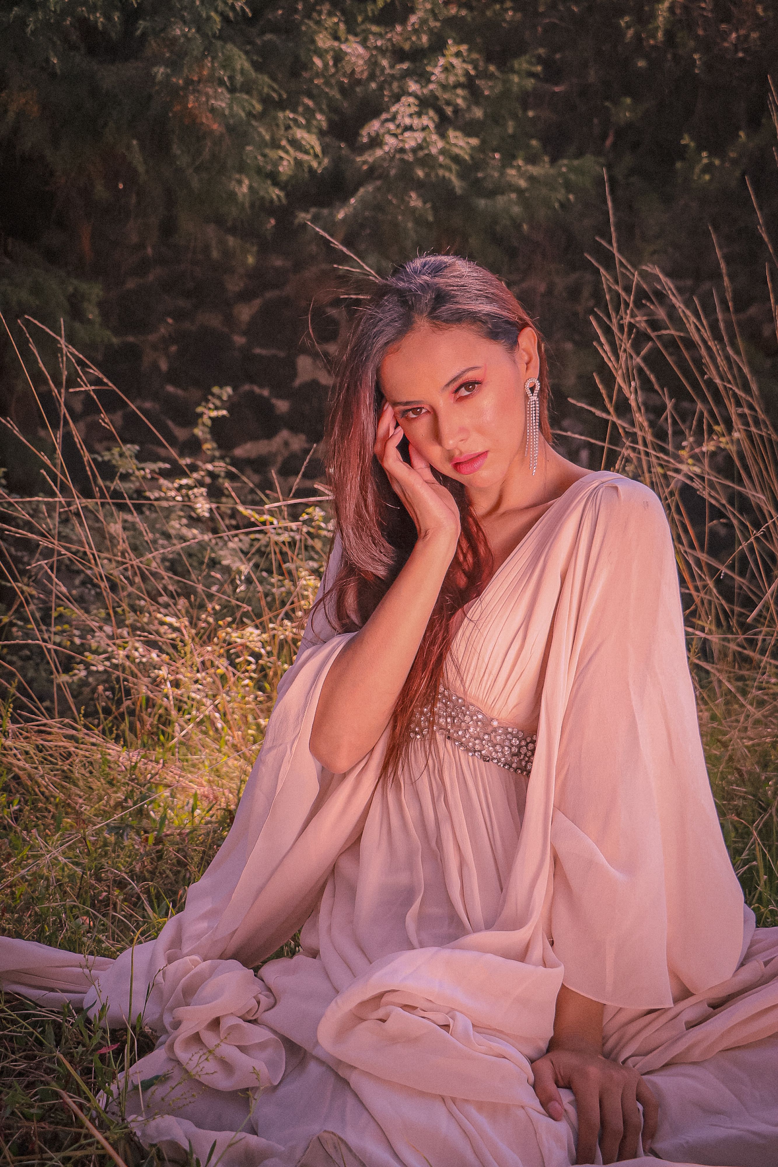 Fotomural Retrato de una mujer con un vestido rosa rodeada de naturaleza, irradiando elegancia y gracia.