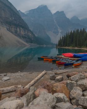 Beautiful canoes on Moraine Lake with a mountainous backdrop in Banff National Park, Canada.