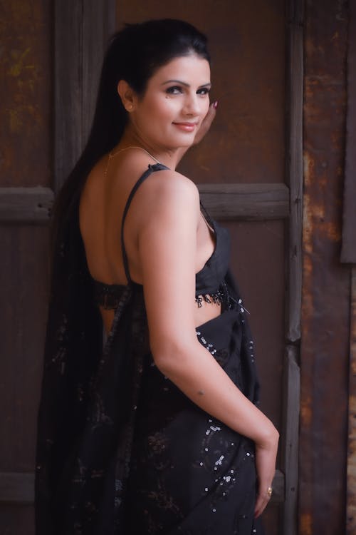 A beautiful woman in black sari posing for the camera