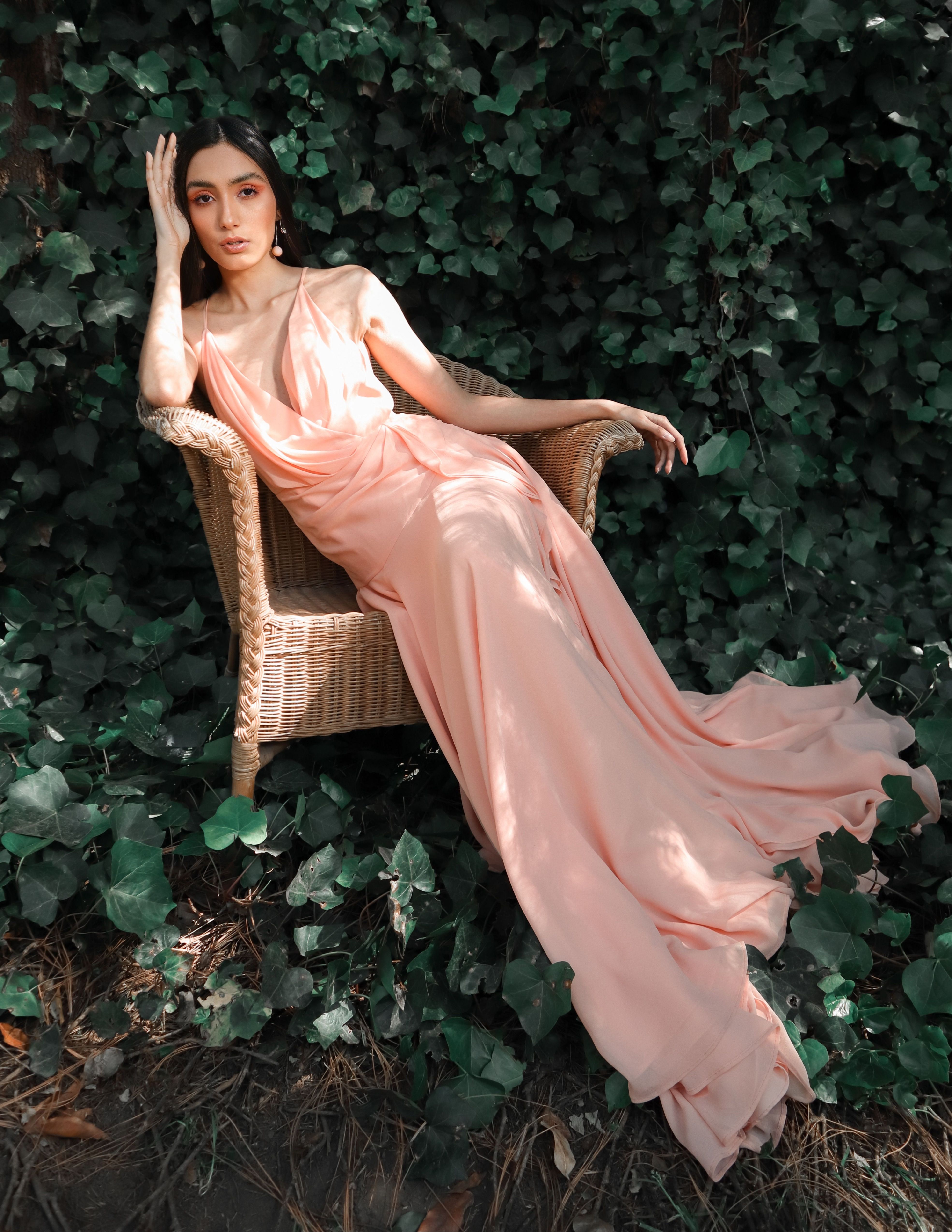 Woman in a Pink Dress Sitting on a Chair near Bushes · Free Stock Photo