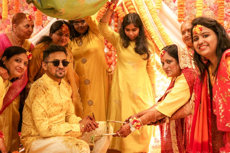 A joyful Indian sangeet celebration with family dancing in traditional attire