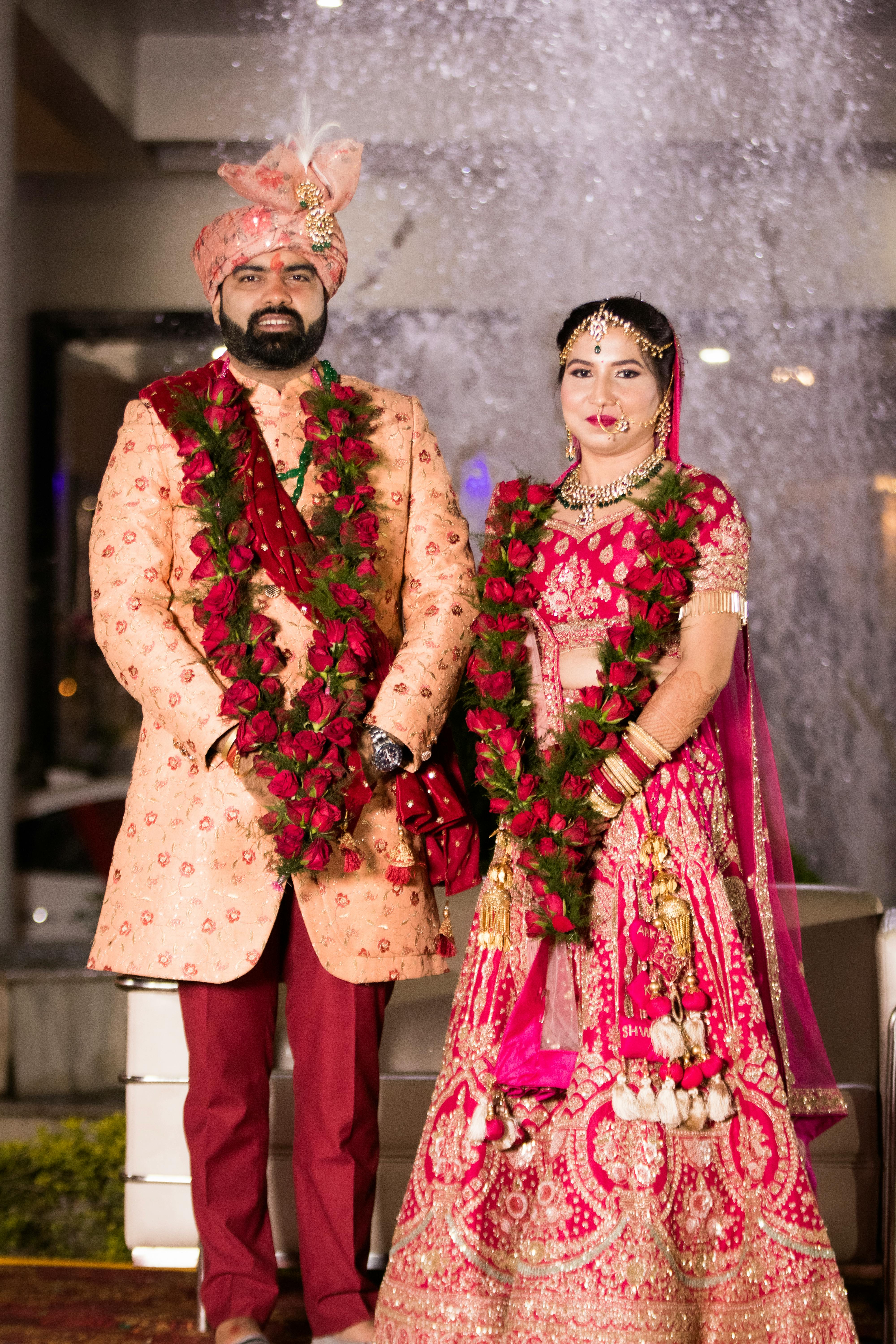 Bride and Groom in Traditional Wedding Clothing Standing near a Fountain Free Stock Photo