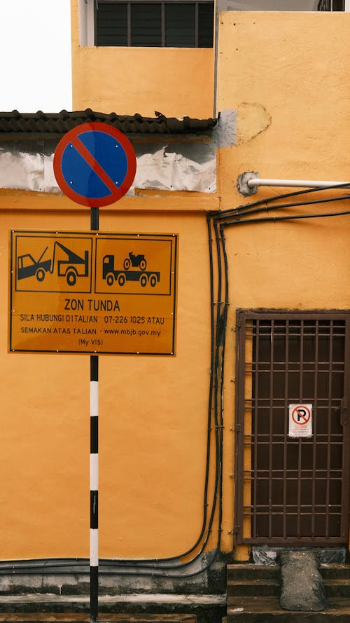 Road Sign near Building Wall