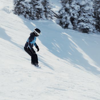 A snowboarder enjoying a thrilling descent on a scenic snowy slope on a bright winter day.