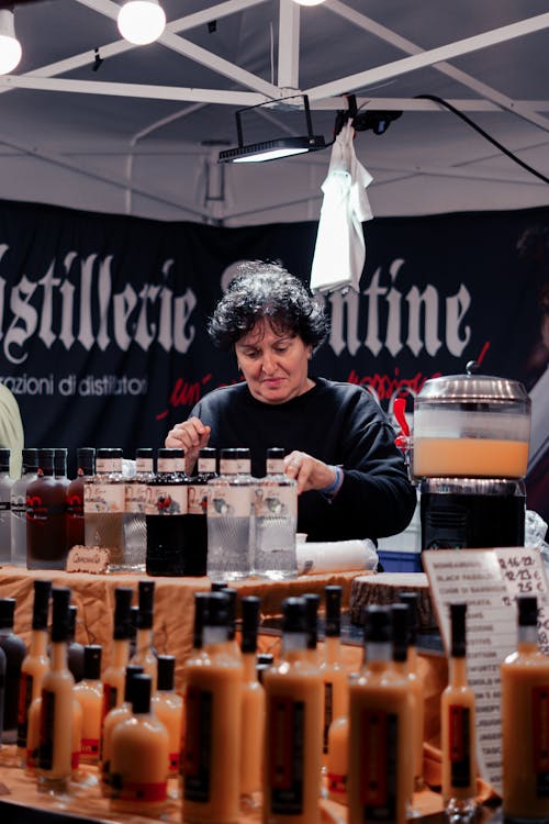 A woman is selling wine at a market