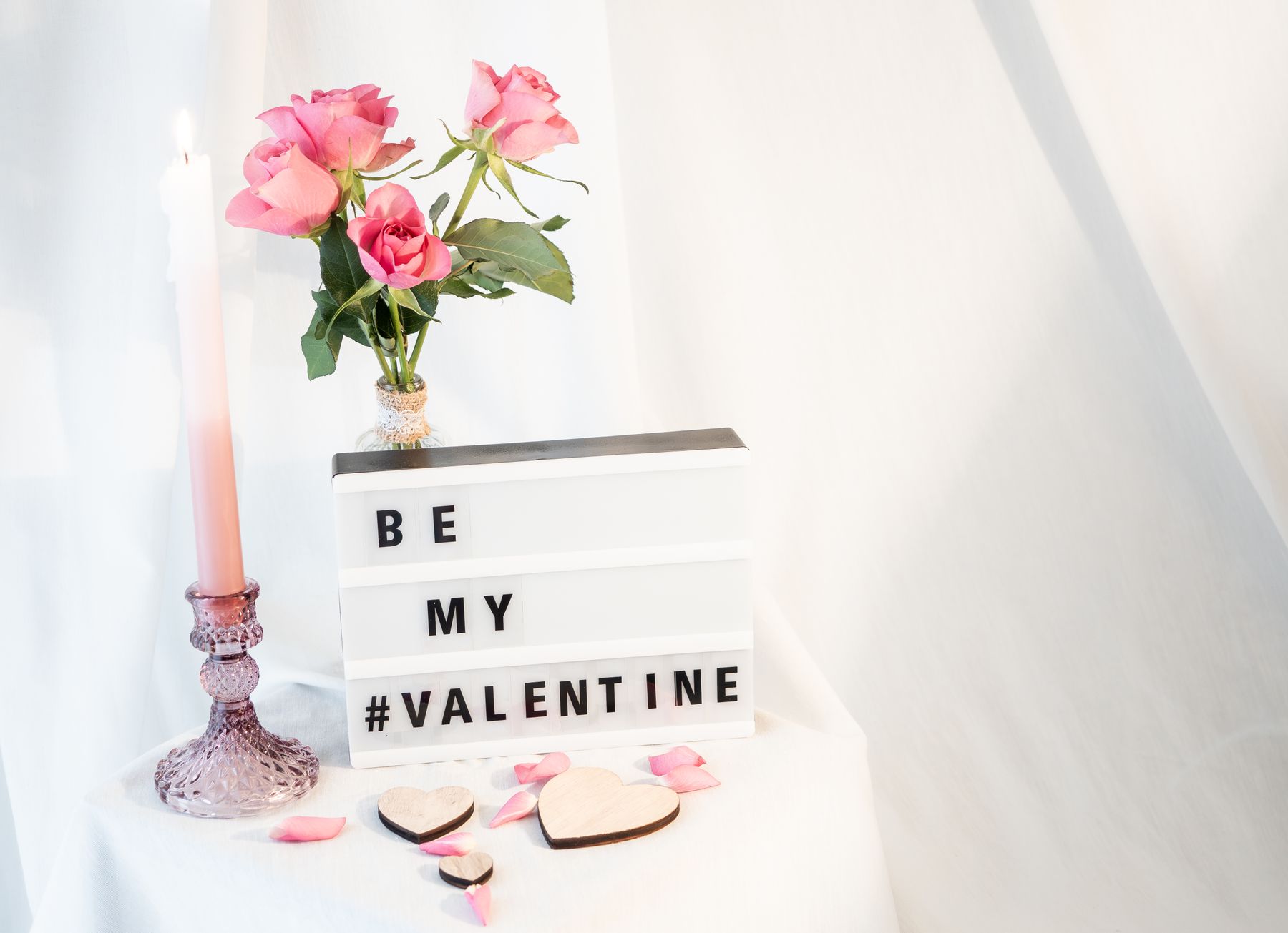 Pink roses, candle and small Valentine's message board