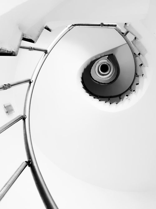 Free Elegant black and white spiral staircase with metal handrail captured from a low angle. Stock Photo