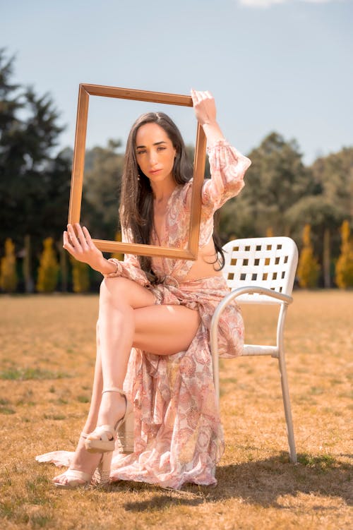 A woman sitting on a chair holding a frame