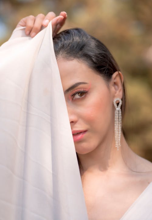 A woman in white dress with long earrings