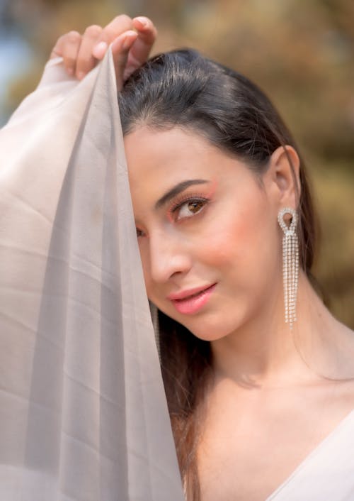 A beautiful woman wearing a veil and earrings