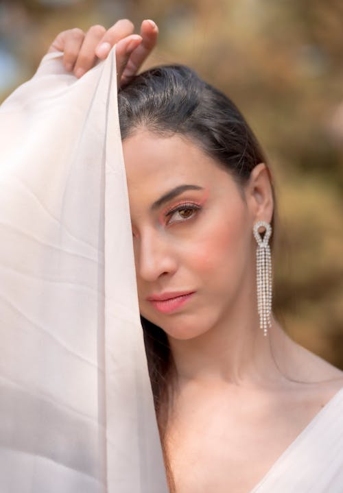 A woman in white dress with long earrings