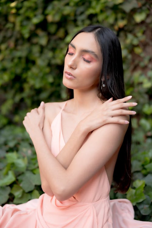 A woman in a pink dress poses for a photo