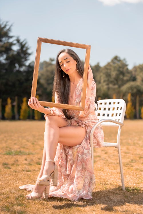 A woman sitting on a chair holding a picture frame