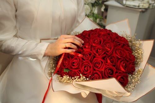 Close up of Bride Hand Holding Bouquet of Red Roses