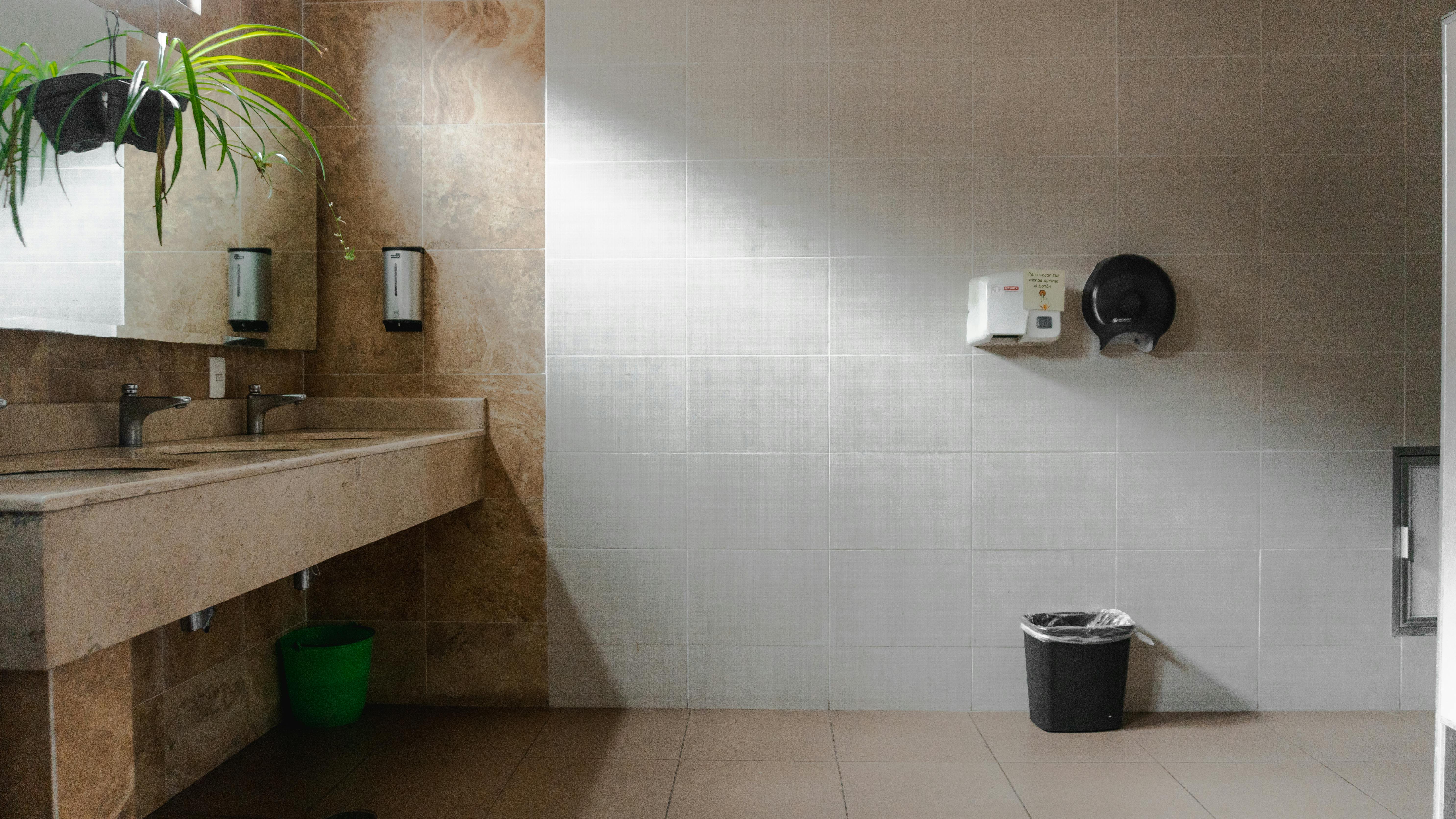 sinks and a hand dryer in the public toilet