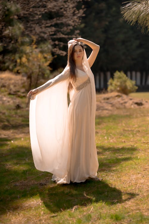 Woman in White Dress Standing on Grass