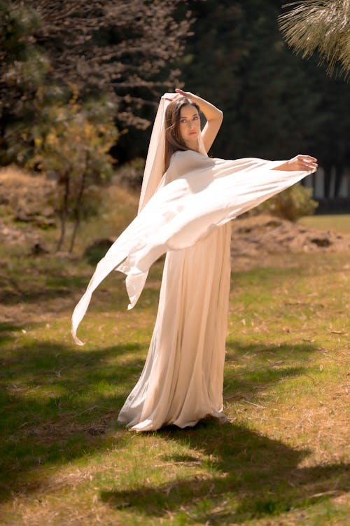 A woman in a white dress is holding a white cloth