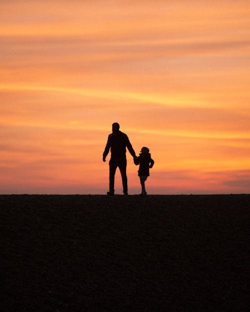 Yellow Sky over Father Walking with Daughter at Sunset