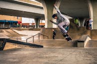 在城市滑板公园里，熟练的滑板运动员展示着技巧、运动与风格