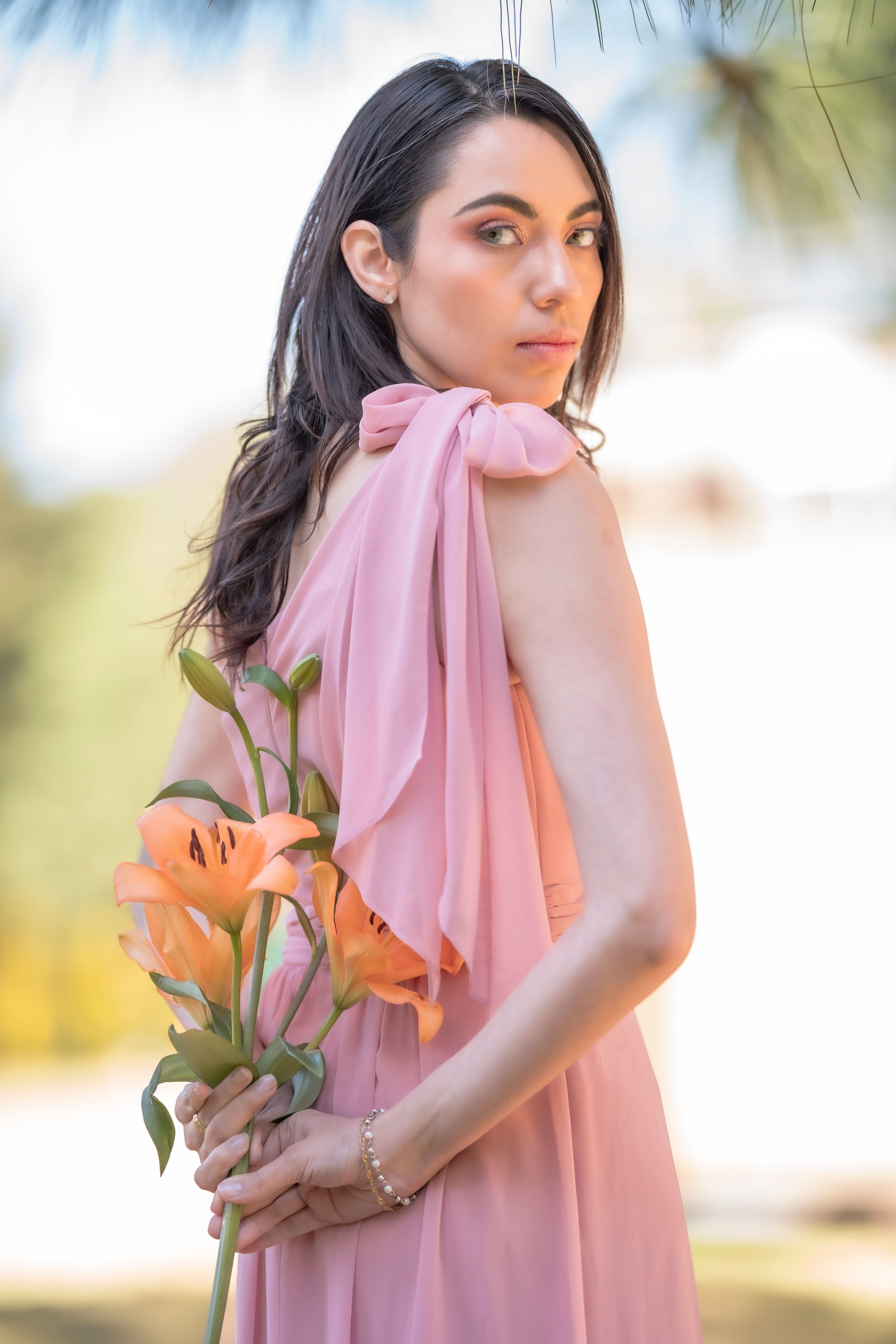 Woman in Pink Dress and Holding Flowers · Free Stock Photo