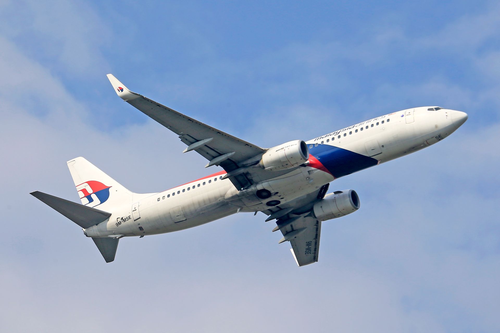 Boeing 737 aircraft soaring through a clear blue sky, showcasing modern aviation.