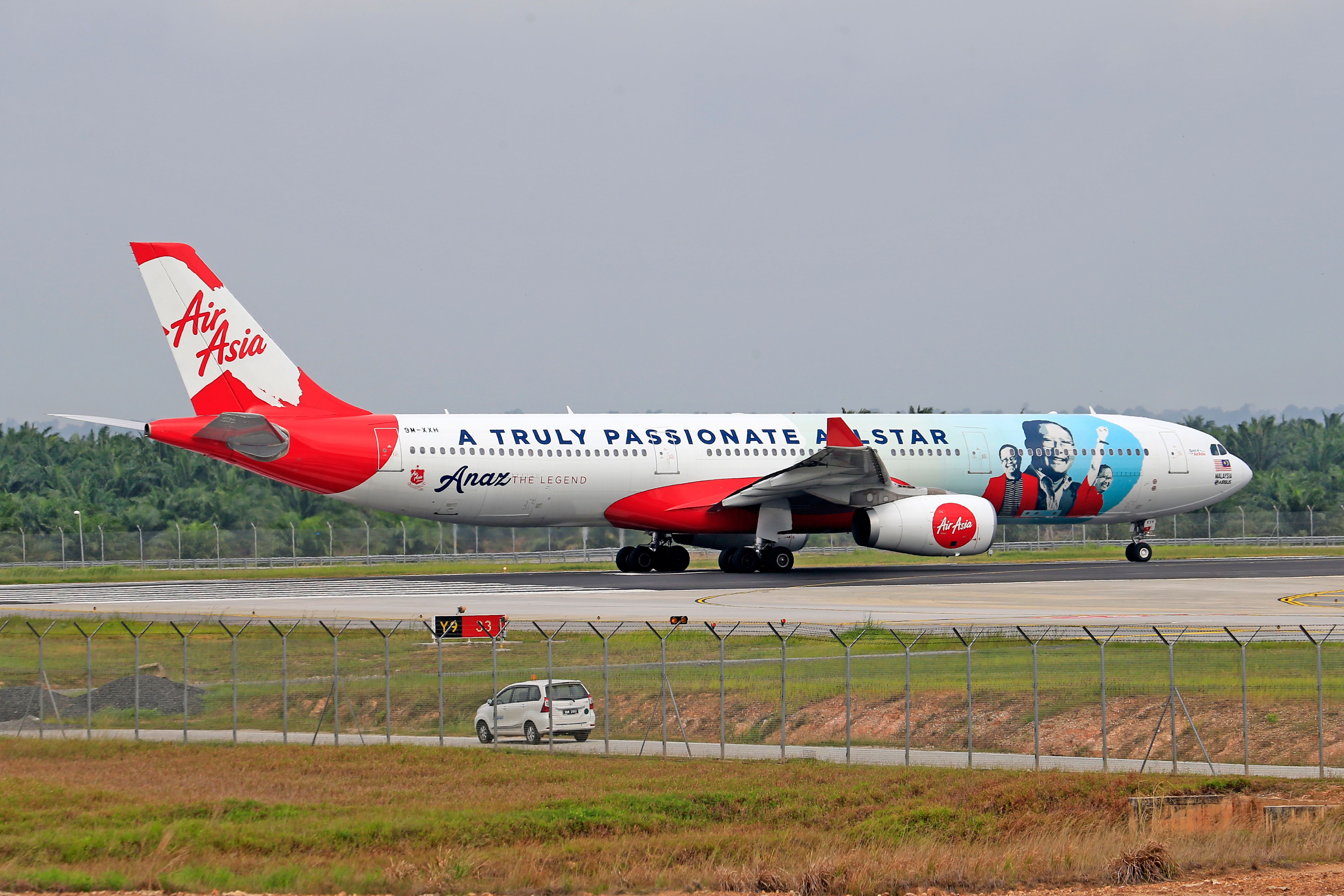 Side view of an AirAsia Airbus A330-343 taxiing on the airport runway.