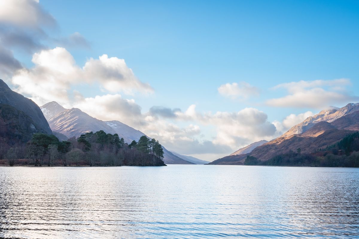 Loch Shiel surrounded by mountains under a cloudy sky
