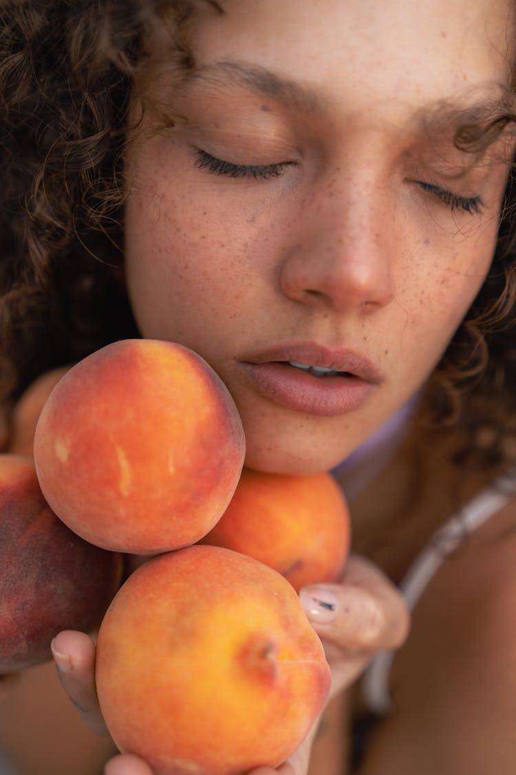 Young Woman With Freckles Posing With Peaches