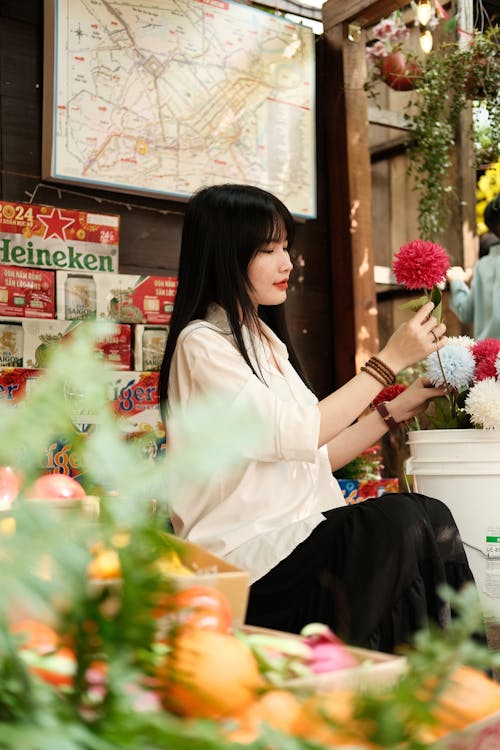 A woman is sitting at a table with flowers