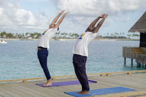 Men Exercising Yoga on Tropical Sea Shore