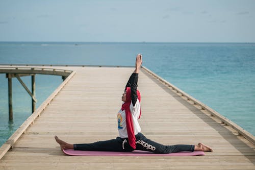 Woman Exercising Yoga on Pier on Sea Shore
